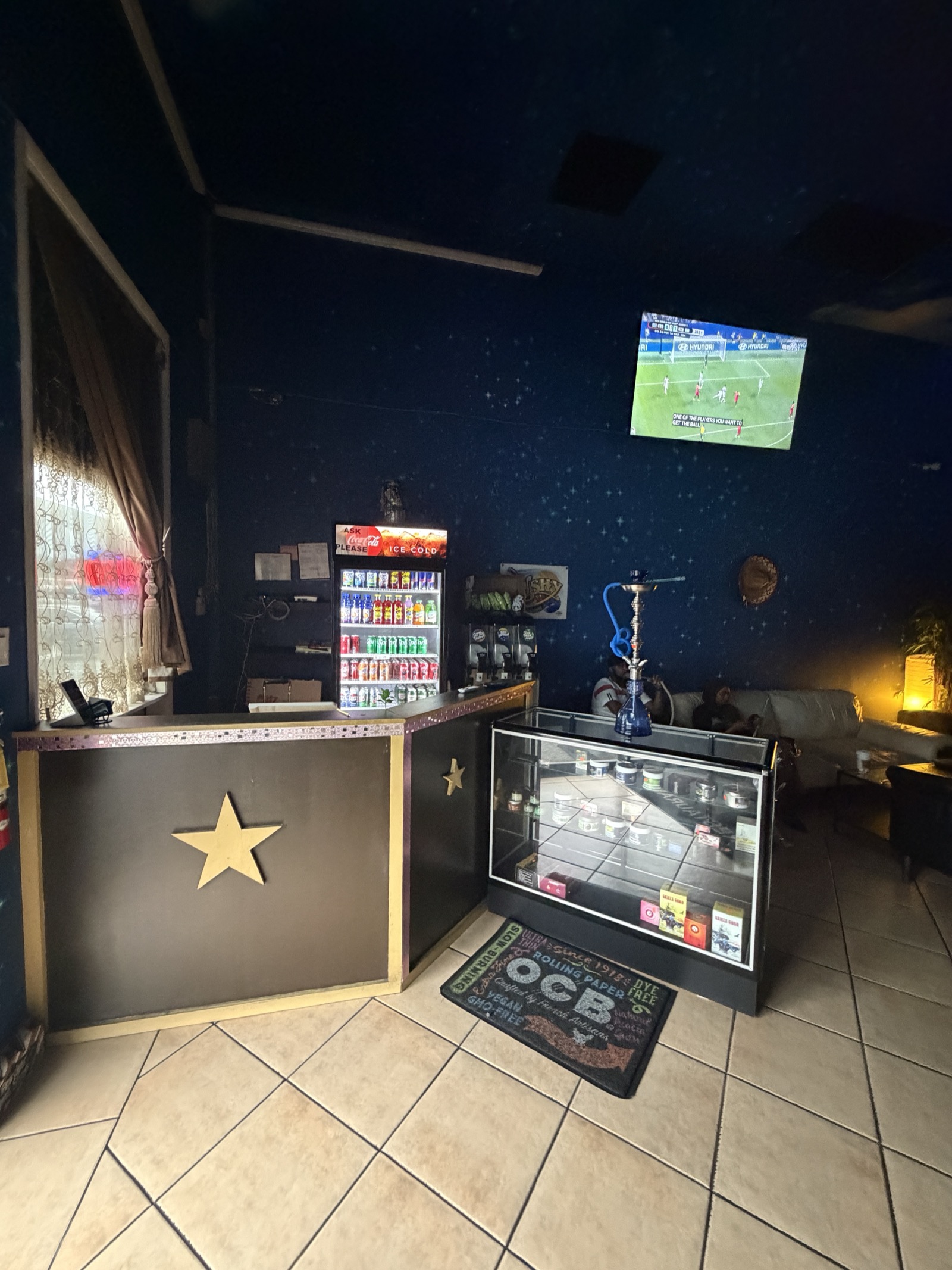 Star Light Cafe counter with gold star emblem and hookah display case
