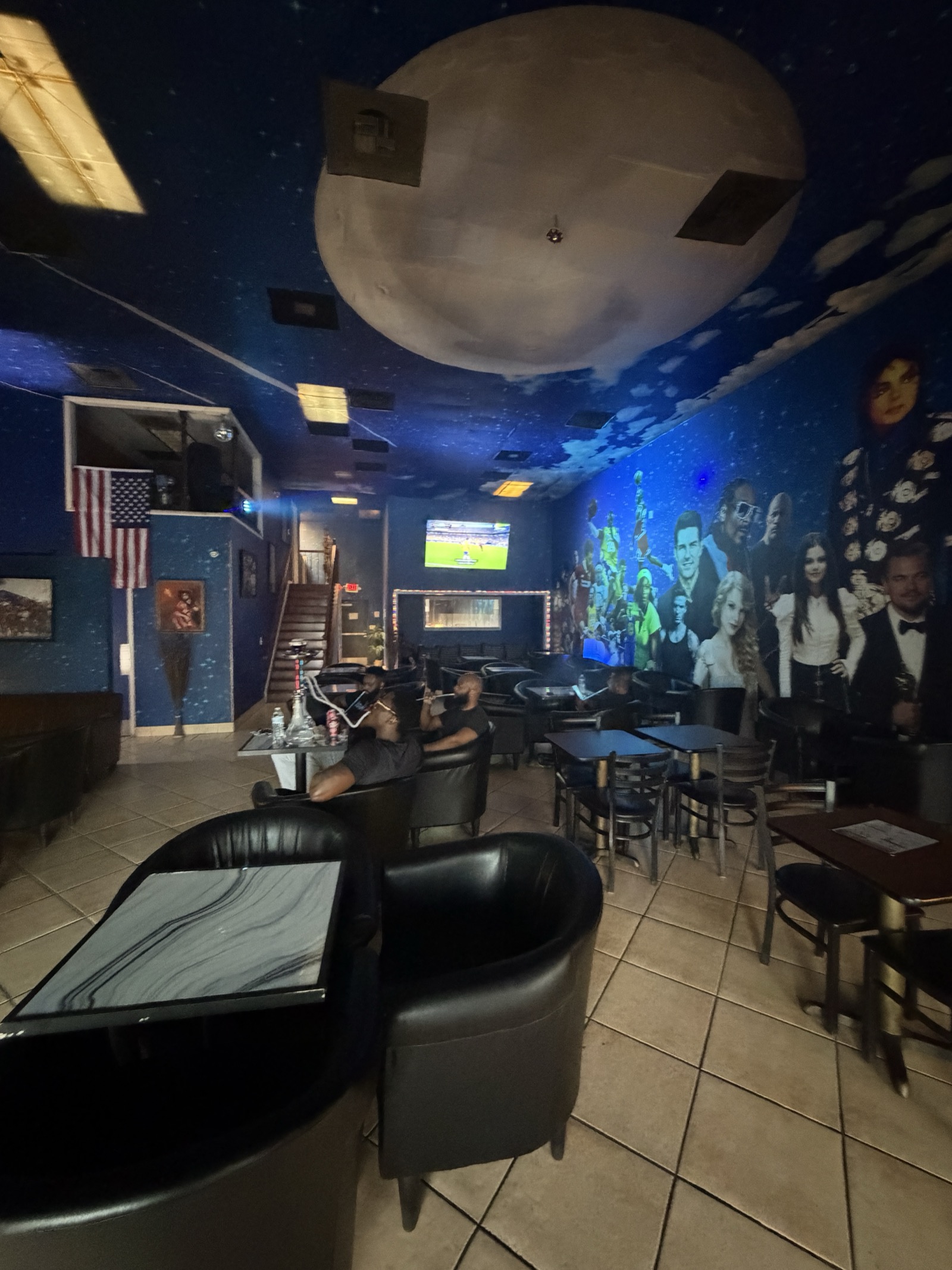 Star Light Cafe main lounge with galaxy-painted walls, moon ceiling mural, and leather seating