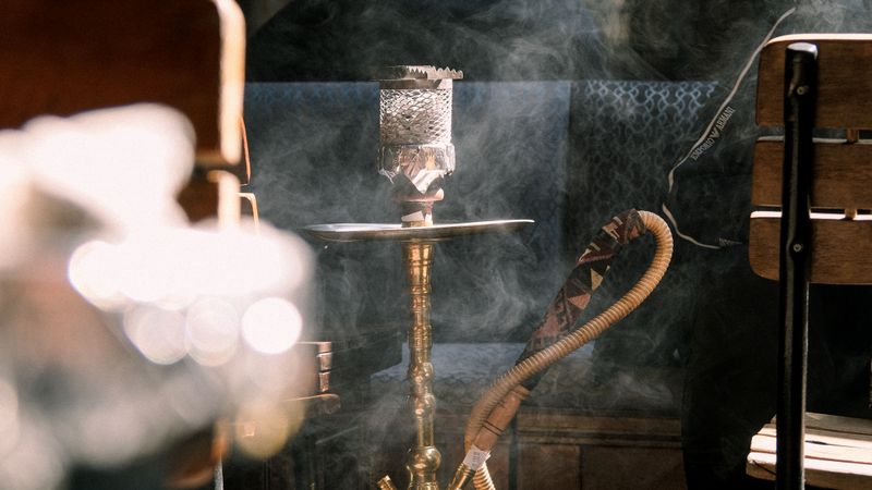 Hookah pipe with smoke in a cozy cafe setting